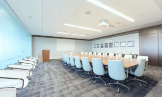 Large board room with white office chairs surrounding a long rectangle table