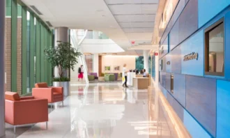 A sun lit hallway with seating and a reception desk