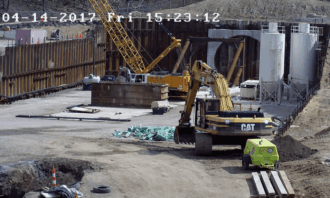 Large construction site with excavators, cranes, and concrete structures